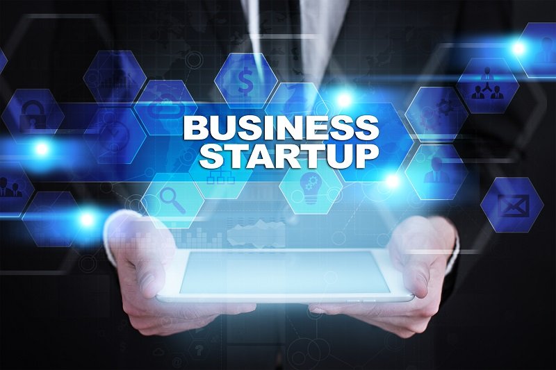 Businessman holding tablet PC with the words 'Business Startup' overlaid