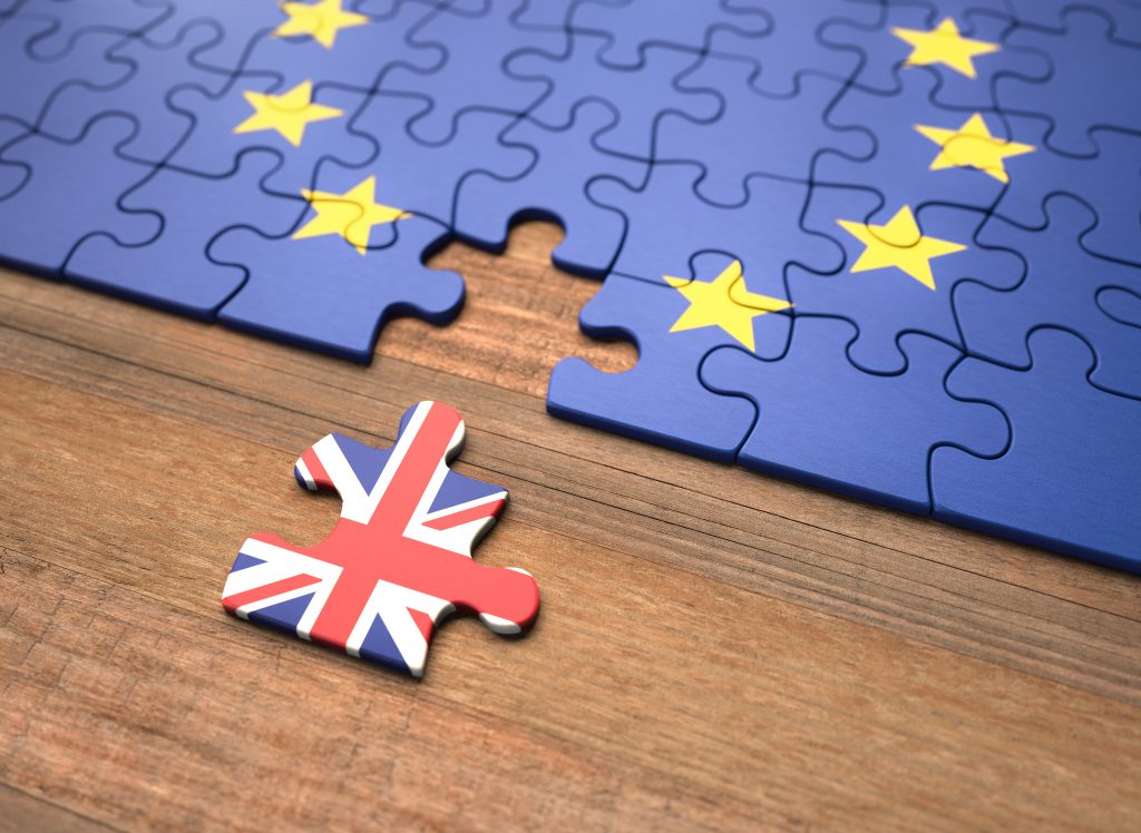 Jigsaw puzzle of the EU flag with a jigsaw piece removed showing the UK Union Jack flag. This represents the UK leaving the EU.