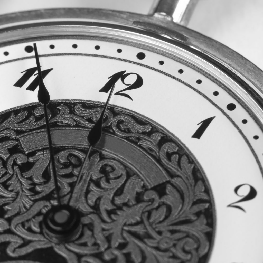 Close up black and white photograph of a clock face. It's All About You to save time