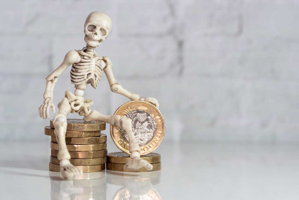 A toy skeleton figure sat on a stack of coins to represent horror stories of bad bookkeeping in a light hearted way.