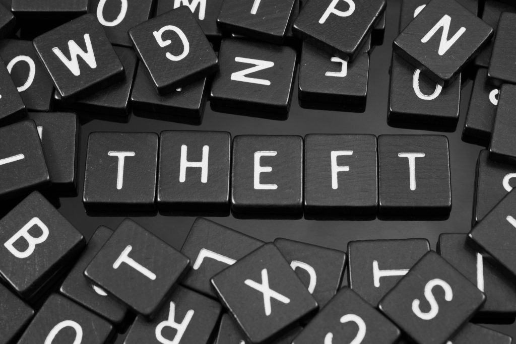 The word Theft in capitals in white letters on black tiles