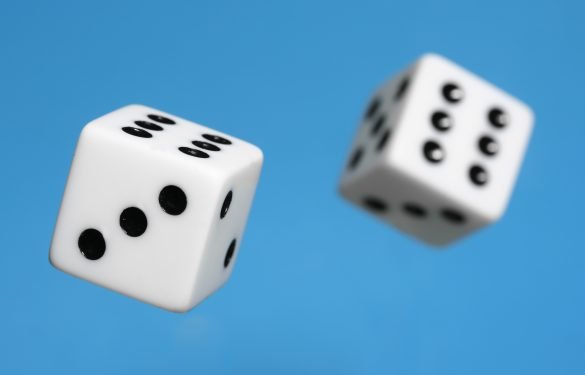 Two Dice being roled - mid air, isolated blue background
